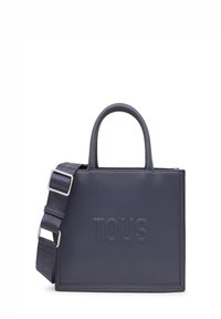 Bolso tote de cuero navy con el logo "TOUS" grabado, dos asas superiores y una correa de hombro desmontable con herrajes plateados ajustables.