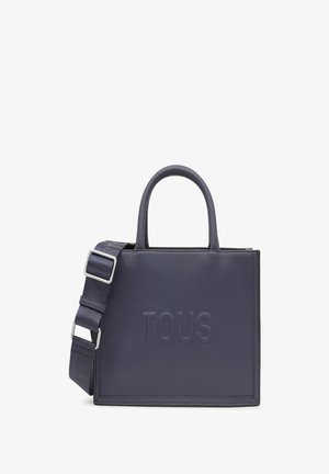 Granatowa skórzana torba tote z wytłoczonym logo "TOUS", dwoma górnymi uchwytami oraz odpinanym paskiem na ramię z regulowanym srebrnym okuciem.