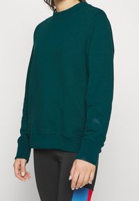 Donkerblauwe sweatshirt van een zachte katoenen mix, met een ronde hals, lange mouwen, ribgebreide boorden en een iets verkorte zoom.