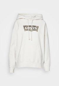 Bílá mikina s klokanní kapsou, s logem v designu leopardího vzoru na hrudi. Má kapuci se stahovací šňůrkou a žebrované manžety.