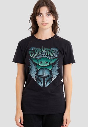 Black cotton t-shirt featuring a graphic print of a character with green accents and a helmet, surrounded by stylized smoke-like patterns.