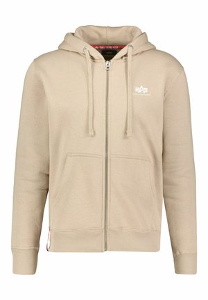 Beige zip-up hoodie with a drawstring hood, front pockets, ribbed cuffs and hem, featuring a logo on the left chest and soft texture.