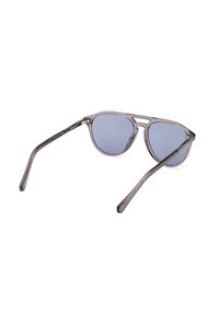 Gafas de sol de acetato gris con lentes tintados de azul, que presentan un diseño minimalista, una forma elegante y patillas delgadas.