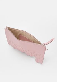 Rozā ādas somiņa ar teksturētu, izcilu logotipa dizainu. Ar rāvējslēdzēja aizvēršanu un gludu iekšējo oderi. Iekļauj noapaļotu, viļņotu malu.