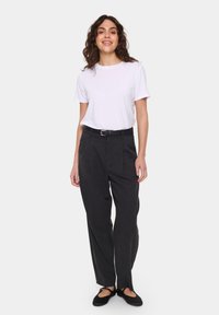 Pantaloni negri formali cu o croială ajustată și bucle pentru curea, asortați cu un tricou alb simplu și pantofi negri fără toc. Textură de țesătură netedă.
