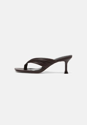 Sandale tongs marron foncé à talon étroit et courbé de 7 cm avec des brides en cuir rembourrées et plissées.