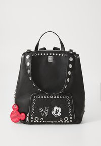 Zaino in pelle nera con borchie argentate, tasca anteriore con zip decorata con design di Topolino e un charm rosso di Topolino attaccato.