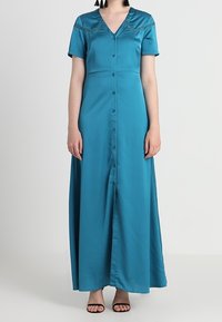 Teal satin maxi dress with short sleeves, V-neckline, and decorative trim. Features front button closure and a straight silhouette.