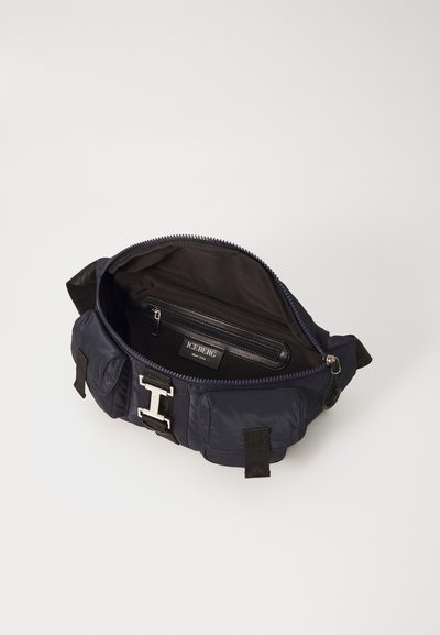 Navy nylon bag with a zippered top, featuring a silver metal clasp, black fabric lining, and an inner pocket for organization.
