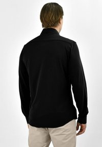 Zwarte lange mouw shirt met een klassieke kraag, knoop manchet en een rechte zoom. De stof lijkt glad zonder zichtbare patronen.