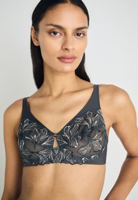 Gray bra featuring floral embroidery with green accents, a V-neckline, and a keyhole detail at the center.