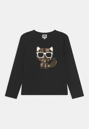 Camiseta negra de manga larga con un gráfico de un gato en un patrón de camuflaje marrón brillante que lleva gafas de sol blancas. Etiqueta de la marca visible.