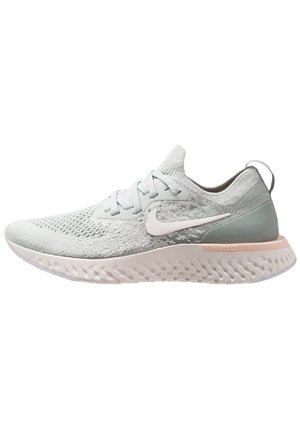 Lysegrå Nike løbesko med strikket overdel, hvid swoosh-logo, polstret tekstureret sål og trækflap på hælen.