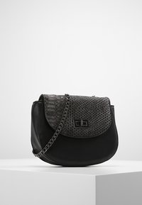 Černá kožená kabelka s oblým tvarem; má texturovaný černý klopový detail se vzorem hadí kůže a stříbrný řetězový popruh. Černé kovové akcenty.