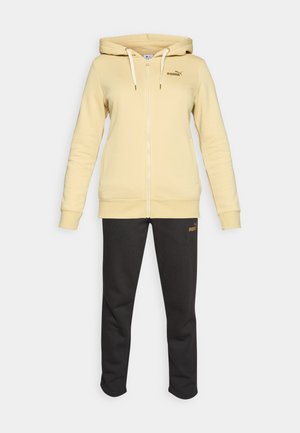 Beige huppari vetoketjulla ja nauhoilla sekä mustat slim-fit-housut, molemmat pieniä Puma-logoja yksinkertaisella valkoisella taustalla.