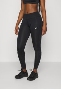 Leggings deportivos negros con un diseño ajustado, que cuentan con una cintura alta, una textura suave y un pequeño logo en el muslo.