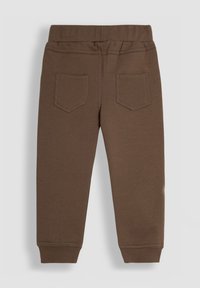 Pantalones de chándal marrones de algodón con cintura elástica, diseño de piernas ajustadas y dos bolsillos traseros con un sencillo patrón de costura.