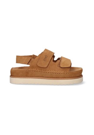 Sandalias de ante marrón con correas de Velcro ajustables, que cuentan con una suela acolchada y una suela exterior de goma blanca. Costuras detalladas en los lados.