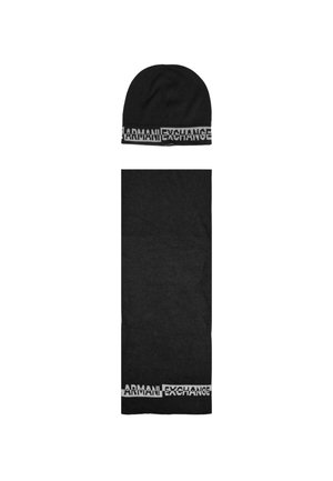 Conjunto de gorro de punto negro y bufanda a juego, que presenta un audaz logo blanco "ARMANI EXCHANGE" a lo largo del borde inferior de ambas piezas.
