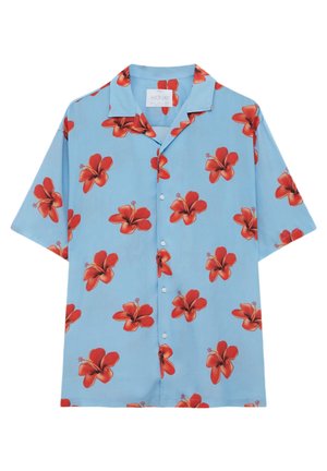 Chemise bleu clair à manches courtes avec des boutons et un motif de fleurs d'hibiscus rouges, col ouvert.