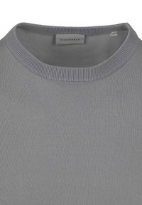 Lichtgrijze trui met een ribbelende ronde hals, een gladde textuur en het label "Suitable" binnen de kraag, met een medium maatlabel.