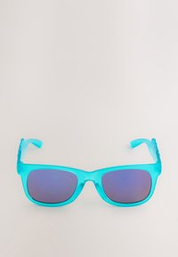 Helle türkisfarbene, rechteckige Sonnenbrille mit blau getönten Gläsern, die auf einer hellen, flachen Oberfläche liegt.
