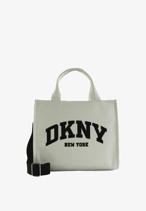 Petit sac fourre-tout gris clair avec des poignées courtes, une bandoulière noire réglable, et "DKNY New York" imprimé en grandes lettres noires.