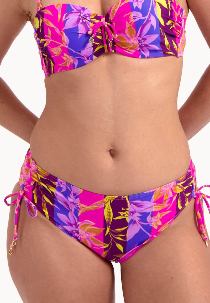 Wielokolorowy bikini z fioletowymi, różowymi i żółtymi wzorami kwiatowymi. Górna część ma marszczony fason z wiązaniami, a dół ma boczne wiązania.