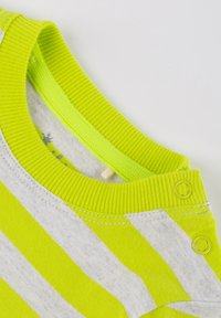 Green striped shirt with a ribbed neckline, featuring buttons and a soft, lightweight fabric. The design combines bright and neutral tones.