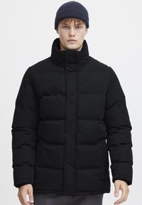 Black puffer jacket with a high collar, featuring quilted sections and a front zipper. Texture appears smooth and padded.