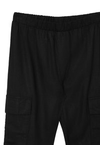 Schwarze Hose aus strukturiertem Stoff, mit einem elastischen Bund und Seitentaschen für Stauraum, die eine entspannte Passform betont.