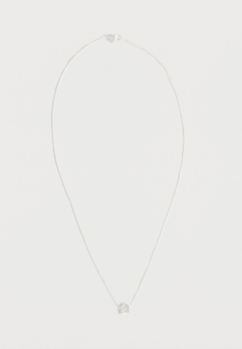 Collier délicat en chaîne argentée avec un petit pendentif en forme de lettre minuscule "a" et un fermoir simple sur fond blanc.