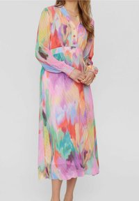 Robe longue et colorée en tissu transparent arborant un motif tie-dye aux nuances de rose, bleu et orange. Encolure en V à boutons et poignets élastiqués.