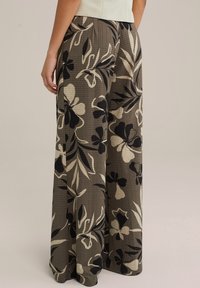 Hlače širokih nogavic iz teksturirane tkanine z rjavim osnovnim tonom in belimi ter črnimi cvetličnimi motivi. Poudarjene z visokim pasom.