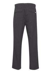 Zwarte broek van geweven stof. Kenmerken zijn een recht gesneden pijp, riemlussen en twee achterzakken met kleppen. Eenvoudig ontwerp.