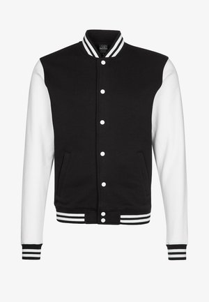 Schwarz-weißes College-Jackett mit Druckknopfverschluss, gestreiften Bündchen und zwei Seitentaschen; hat einen einfarbigen schwarzen Körper und weiße Ärmel.