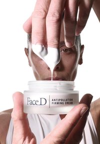 Barattolo di vetro bianco etichettato "FaceD CREMA FIRMANTE ANTIPOLLUTIVA" tenuto in un mano, con una densa crema bianca prelevata con le dita.