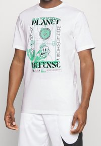 Bílá bavlněná tričko s zeleným grafickým designem, textem, ilustrací basketbalového hřiště a akcentem v podobě usměvavé květiny.