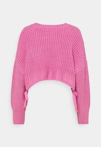 Maglione corto lavorato a maglia rosa con texture a costine, maniche lunghe e nastri laterali. La parte posteriore presenta una scollatura rotonda e una vestibilità ampia.