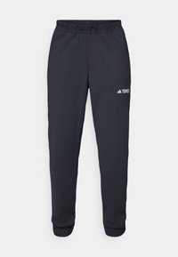 Schwarze Sporthose aus glattem Material, mit einem elastischen Bund, schmal zulaufenden Beinen und einem kleinen weißen Logo auf dem linken Oberschenkel.