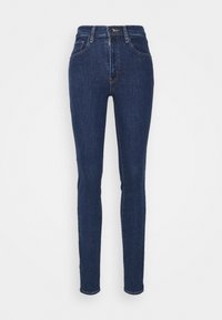 Jeans ajustados de talle alto en azul oscuro, hechos de mezclilla, con cierre de cremallera y botón, de textura suave y sin patrones visibles.