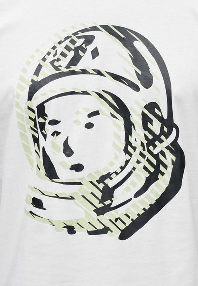 Λευκό βαμβακερό T-shirt με γραφικό αστροναύτη σε μαύρο και ανοιχτό πράσινο. Ο σχεδιασμός περιλαμβάνει διαγώνιες γραμμές και απληστευμένη λεπτομέρεια προσώπου.