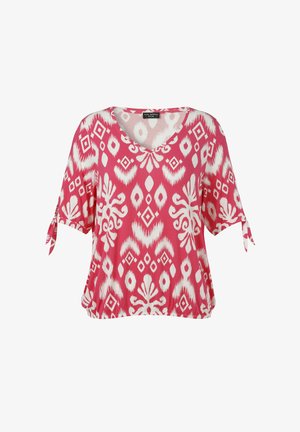 Roze blouse met korte mouwen, met witte abstracte geometrische en bloemmotieven, V-hals en kleine strikjes aan het uiteinde van de mouwen.