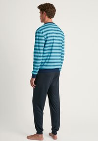 Blauw gestreepte longsleeve top met marineblauwe accenten en donkere broeken, gemaakt van zachte stof, met een losse pasvorm en rib gebreide manchetten.