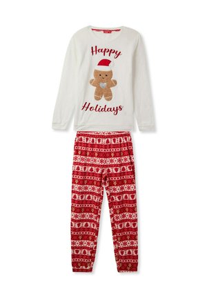 Maglietta da pigiama bianca a maniche lunghe con un design di gingerbread e testo "Buone Feste", abbinata a pantaloni da pigiama rossi con motivo decorativo natalizio.