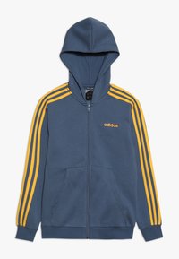Blue zip-up hoodie with yellow Adidas stripes along sleeves and small Adidas logo on chest, featuring front pockets and cuffed sleeves.