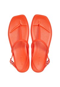 Chanclas de color naranja brillante hechas de un material flexible, con un poste ancho para los dedos, una plantilla texturizada y una correa para el tobillo ajustable.