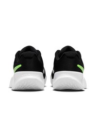 Μαύρα αθλητικά παπούτσια με επάνω μέρος από δίχτυ, με λευκές σόλες και νεον πράσινη λεπτομέρεια στη φτέρνα. Απλός σχεδιασμός που τονίζει την άνεση.