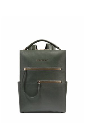 Sac à dos en cuir vert foncé avec poignée supérieure, deux poches zippées à l'avant et logo métallique de la marque centré au-dessus des fermetures éclair.