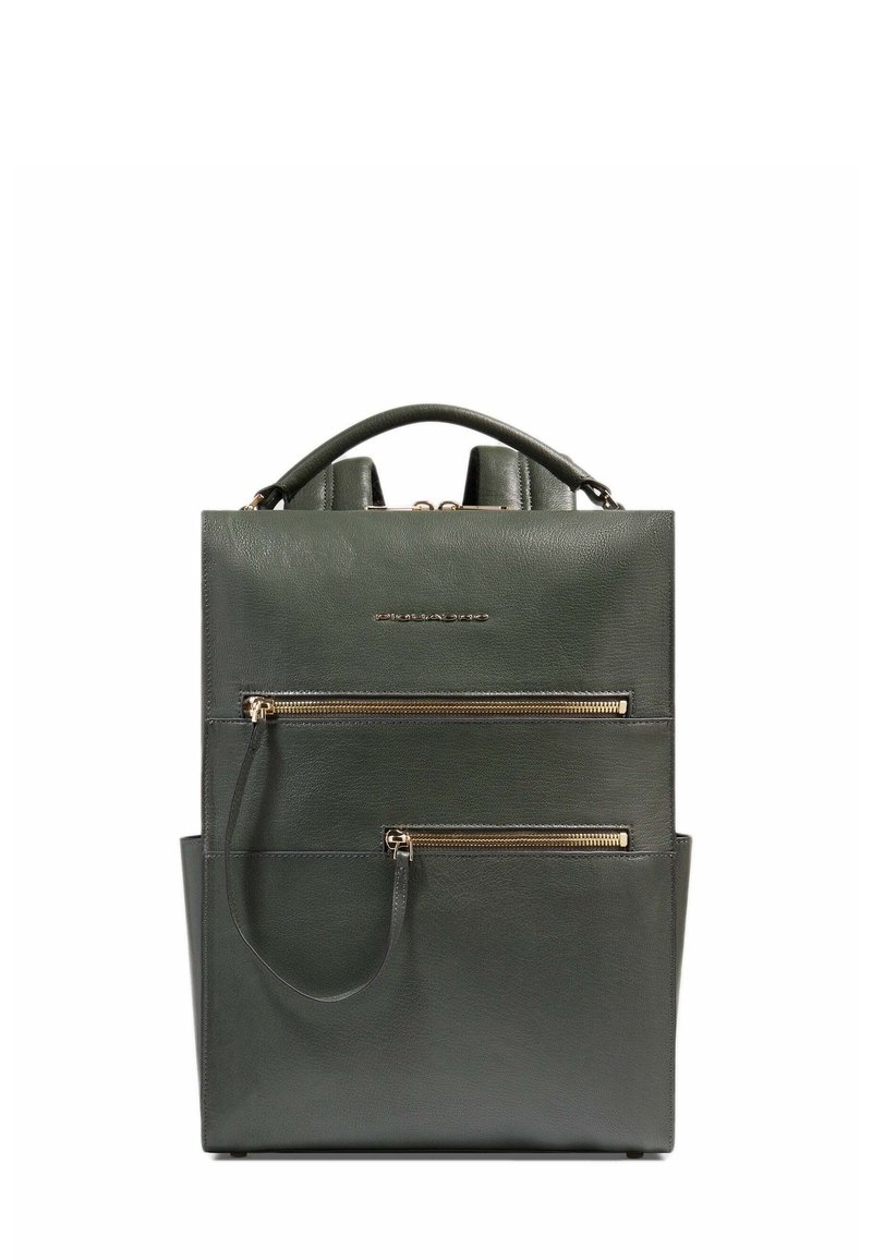 Sac à dos en cuir vert foncé avec poignée supérieure, deux poches zippées à l'avant et logo métallique de la marque centré au-dessus des fermetures éclair.